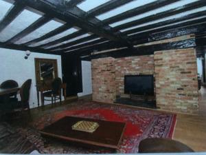 een woonkamer met een open haard en een televisie bij The Star in Lydd