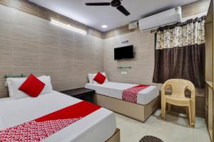 a hotel room with two beds and a tv at Hotel Vallabha Residency in Rājahmundry