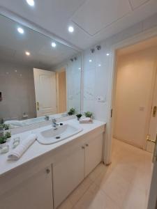 Luxury Apartment in Playas del Duque , Puerto Banus by Holidays & Home في مربلة: حمام مع حوض ومرآة كبيرة