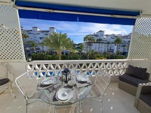 uma mesa e cadeiras numa varanda com vista em Luxury Apartment in Playas del Duque , Puerto Banus by Holidays & Home em Marbella