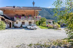 un coche blanco estacionado frente a una casa en Ferienwohnungen am Biobauernhof Lahner en Bramberg am Wildkogel