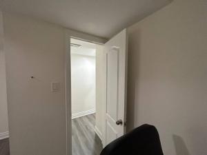 ein leeres Zimmer mit einer weißen Tür und einem Stuhl in der Unterkunft 2 Bedroom private apartment with private entrance in Brampton