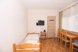 a bedroom with a bed and a table and a desk at Willa Nova - Centrum in Szklarska Poręba