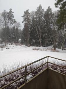 a snow covered field with a fence and trees at Fint boende nära Isaberg Mountain Resort in Grimsås