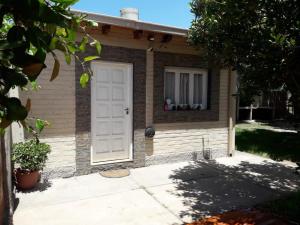 una casa con una puerta blanca y una ventana en Departamento San Rafael en San Rafael