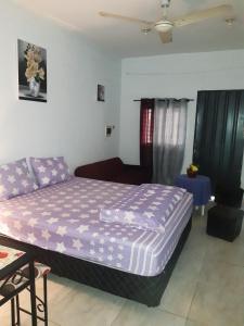 a bedroom with a purple bed and a couch at Adorable monoambiente en Asunción in Asunción