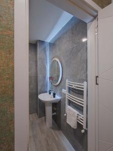 a bathroom with a sink and a mirror at Round Garden Hotel in Tbilisi City