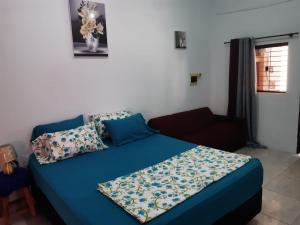 a bedroom with a blue bed and a couch at Adorable monoambiente en Asunción in Asunción