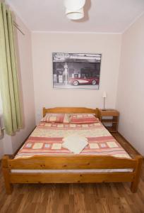 1 dormitorio con 1 cama con una foto de un coche en la pared en Willa Nova - Centrum, en Szklarska Poręba