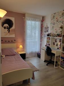sypialnia z łóżkiem, biurkiem i oknem w obiekcie JO 2024 -Appartement familial tout confort w mieście Guyancourt