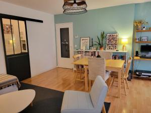 ein Wohnzimmer mit einem Esstisch und Stühlen in der Unterkunft JO 2024 -Appartement familial tout confort in Guyancourt