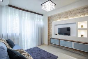 a living room with a tv and a brick wall at GA- Big And Luxury Apartment - In The Center&Grzybowska 5 in Warsaw