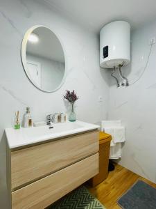a bathroom with a sink and a mirror at Cozy House in Funchal