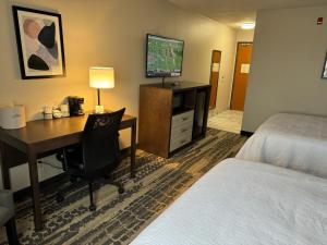 a hotel room with a desk and a bed and a bed and a room with at Wingate by Wyndham Marion in Marion