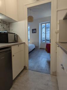 アングレームにあるCharmant studio - Centre ville à pied - Accès facileのキッチン(電子レンジ付)、ベッド1台が備わります。