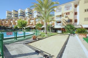 einen Apartmentkomplex mit einem Pool und Palmen in der Unterkunft La Pla House in El Campello
