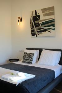 a bed with a blue blanket and pillows on it at Zambujal Suites in Sesimbra