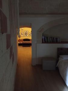 einen Flur eines Zimmers mit einem Bett und einem Sofa in der Unterkunft CASA NEL QUARTIERE DELLE CERAMICHE in Grottaglie