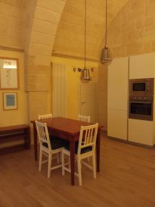 einen Esstisch mit Stühlen und eine Küche in der Unterkunft CASA NEL QUARTIERE DELLE CERAMICHE in Grottaglie