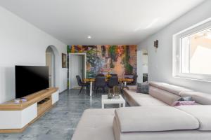 een woonkamer met een bank en een tv bij Residence David in Poreč