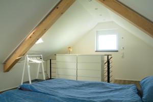 um quarto no sótão com uma cama e uma janela em Ferienhaus mit Alpenpanorama em Deggenhausertal