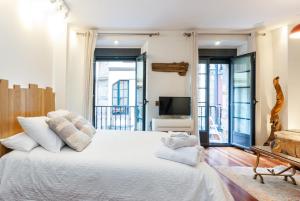 a bedroom with a large white bed and windows at Reino de Asturias, WIFI, VUT155 in Oviedo