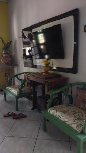 um quarto com uma secretária, uma televisão e uma cadeira em Hostel da Jô em Chapada dos Guimarães