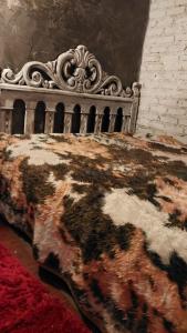 uma cama num quarto ao lado de uma parede de tijolos em Hostel da Jô em Chapada dos Guimarães