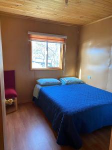靜謐港的住宿－Cabañas El Marmol，一间卧室设有蓝色的床和窗户。