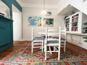 une salle à manger avec une table et des chaises sur un tapis dans l'établissement Charming Two-Bedroom Artist's Residence in Central Penzance, à Penzance