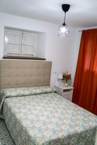 1 dormitorio con cama y cortina roja en Casa Hacha, en Corteconcepción