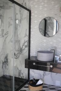 a bathroom with a shower and a sink and a mirror at Zambujal Suites in Sesimbra