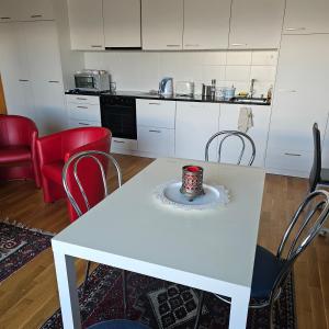 cocina blanca con mesa blanca y sillas en Appartement meublé à louer à Nax, en Nax
