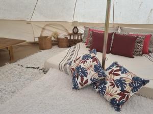 Bett mit Kissen auf einem Teppich in der Unterkunft Ecovila Coração da Mata in Brumadinho