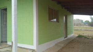 a green wall of a house with a window at Casa V.Giardino pileta y cochera in Villa Giardino