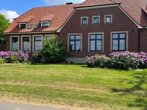 a red brick house with flowers in the yard at Dreckerhook, oasis to slow down! in Raesfeld
