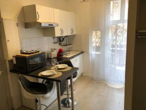 a small kitchen with a table and a microwave at Suite Saint Rome in Toulouse