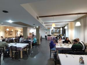 un grupo de personas sentadas en mesas en un restaurante en Hotel Srebrna lisica en Kopaonik