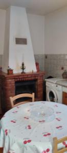 Maison en pierre de taille في Petreto-Bicchisano: مطبخ مع طاولة عليها نمط ورد