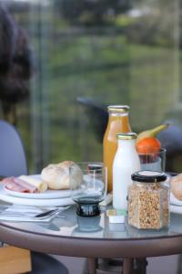 a table with a plate of food and bottles of milk at Zambujal Suites in Sesimbra