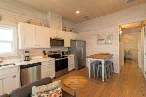 a kitchen with white cabinets and a wooden floor at Beach Bungalow - 2 Suns in Port Aransas