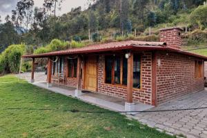 a small brick building with a grass yard at Villa Don Alonso: Casa de Campo in Penipe