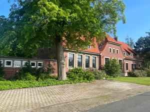 a brick house with a tree in front of it at Dreckerhook, oasis to slow down! in Raesfeld
