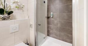 a bathroom with a shower and a toilet at PLAZA INN Regensburg in Regensburg