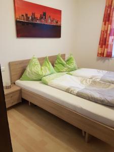 a bed with green pillows on it in a room at Putz Appartements in Gröbming