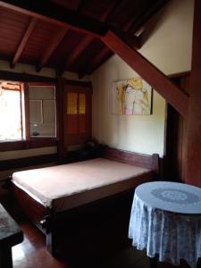 Un dormitorio con una cama y una mesa. en CASA em UBATUBA, en Ubatuba