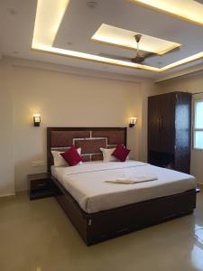 a bedroom with a large bed with red pillows at Kashi Vandanam Homestay in Varanasi