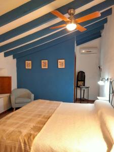 1 dormitorio con pared azul y ventilador de techo en Hostal los Aromas, en Villena