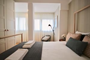 sypialnia z dużym białym łóżkiem i oknem w obiekcie Akicity Amoreiras Jade w Lizbonie