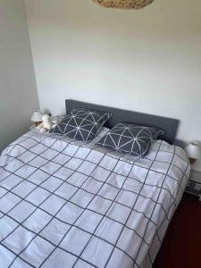 um quarto com uma cama com um edredão cinza e branco em Appmt 4-5 pers pleine nature em Lamoura
